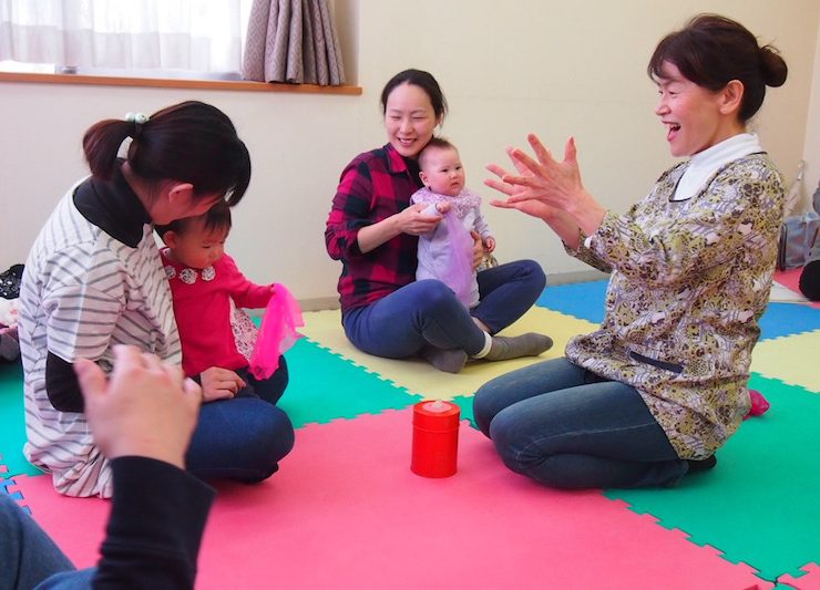 参加する親子と心を通わせながら進めるわらべうたの教室。菅野さん(右)は赤ちゃん一人ひとりに励ましの声をかける