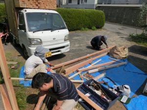 柱が建ったら、柱間の距離を計測して杉材を電ノコでカット。梁を渡す
