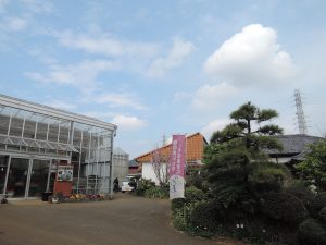 農地と住宅の間にある昔ながらの曲がった道を歩いていくと、道に向かって大きく開けたハウスがある。「山本温室園」の看板が目印