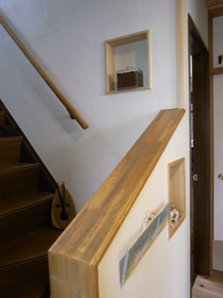 玄関と階段回りは白い土壁で統一。階段の壁にニッチを設け、そこに作品を飾れるようにしている