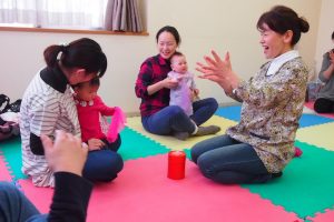 参加する親子と心を通わせながら進めるわらべうたの教室。菅野さん（右）は赤ちゃん一人ひとりに励ましの声をかける