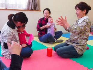 参加する親子と心を通わせながら進めるわらべうたの教室。菅野さん（右）は赤ちゃん一人ひとりに励ましの声をかける