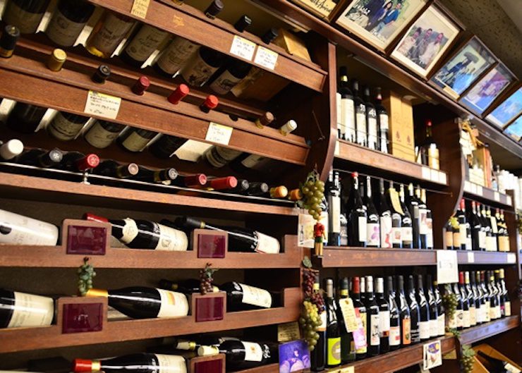 店内へ入ると、棚に所狭しと並ぶワインが目に飛び込んでくる。自然派ワイン以外のワインも厳選されたものばかり。棚上には、現地生産者との思い出の写真が並ぶ
