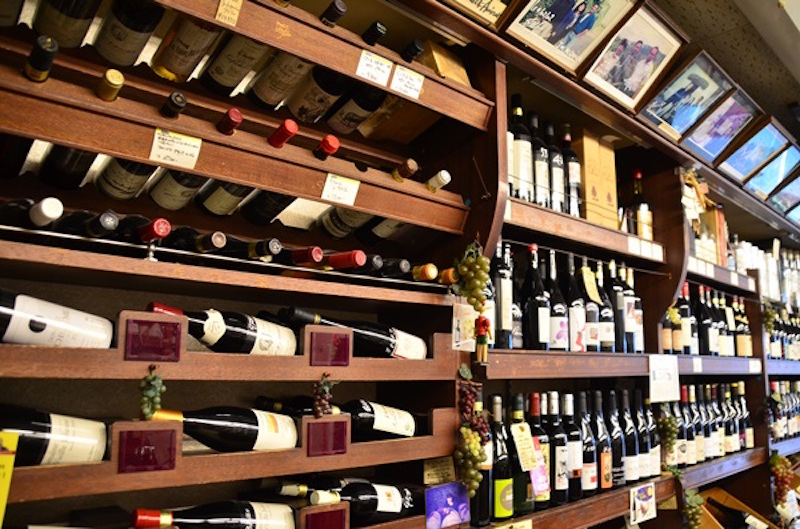 店内へ入ると、棚に所狭しと並ぶワインが目に飛び込んでくる。自然派ワイン以外のワインも厳選されたものばかり。棚上には、現地生産者との思い出の写真が並ぶ