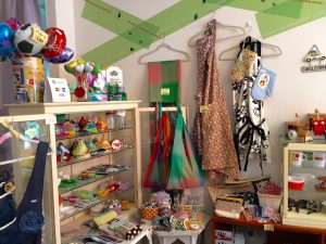 棚に並ぶ可愛い三角帽子のような作品は2個セットでお店の人気商品「鍋つかみ」。この棚にはポップなカラーのキッチングッズが並ぶ。「見て嬉しくなるような、自分の好きなものに囲まれていればそれだけで毎日の家事も気分が上がり、ちょっと幸せな気持ちで暮らせるから」という恵里さんの、主婦目線でのセレクトの数々